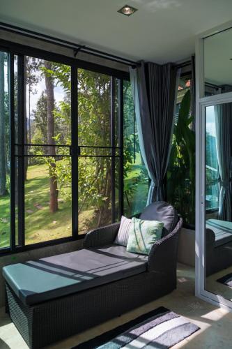 a living room with a couch and a large window at Phu Pha View Doi in Samoeng