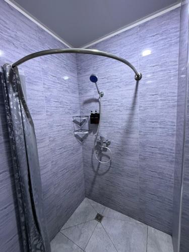 a shower stall with a basket on the wall at ReveL HoteL in Tashkent