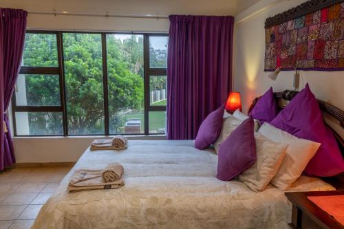 a bedroom with a large bed with purple pillows at The Shores, Ramsgate in Ramsgate