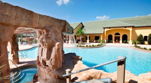 a swimming pool in a resort with a building at Family 4-Bedroom Pool Home Near Disney World in Kissimmee