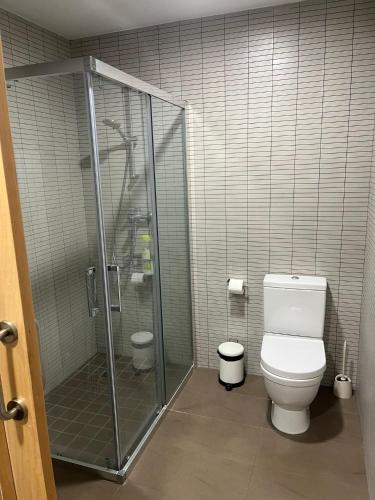 a bathroom with a toilet and a glass shower at Apartamento con encanto in Igualada