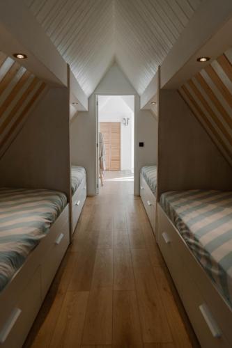 two beds in a room with a hallway at 8 persons Wellness Villa Tulpenacker in Roelofarendsveen