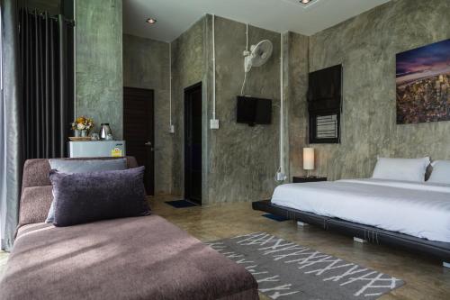 a bedroom with a bed and a couch at Phu Pha View Doi in Samoeng