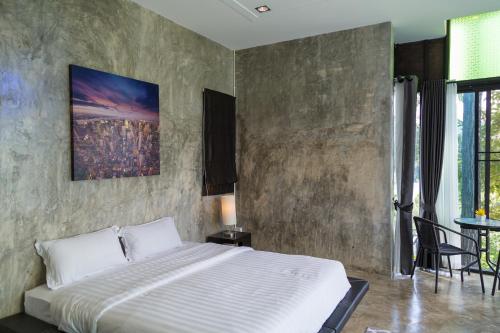 a bedroom with a large bed with a concrete wall at Phu Pha View Doi in Samoeng