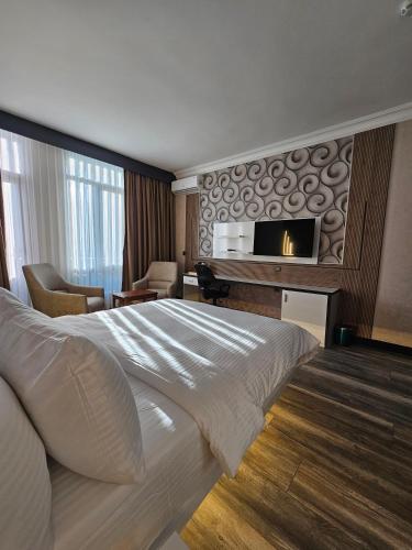 a hotel room with a bed and a flat screen tv at Akgül Otel in Malatya