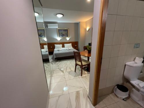 a hotel room with a bed and a bathroom at Piraeus Acropole Hotel in Piraeus