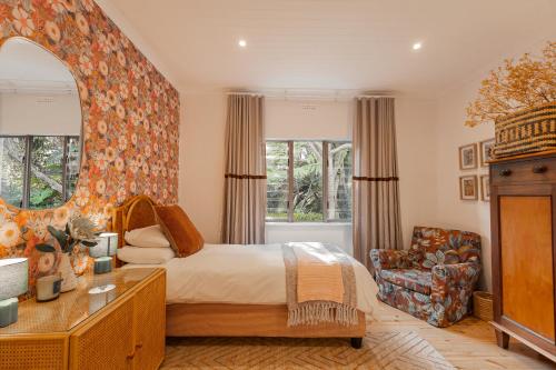 a bedroom with a bed and a chair at Stellenbosch Farm Cottage with Mountain Views in Stellenbosch