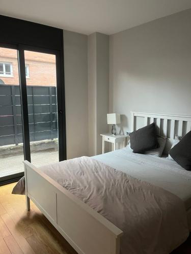a bedroom with a large bed and a large window at Apartamento con encanto in Igualada