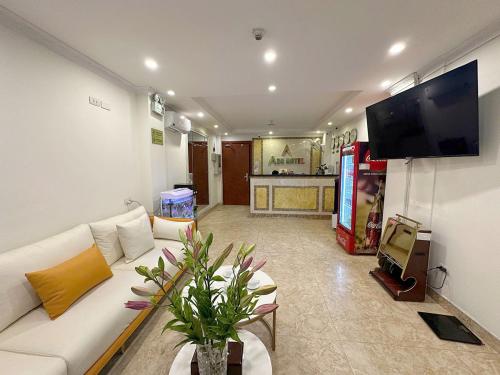 a living room with a white couch and a flat screen tv at A25 Hotel - 109 Trúc Bạch in Hanoi