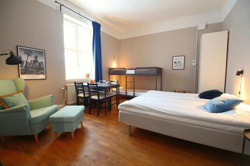 a bedroom with a bed and a chair and a table at Stationshuset bed and breakfast i Ed in Ed