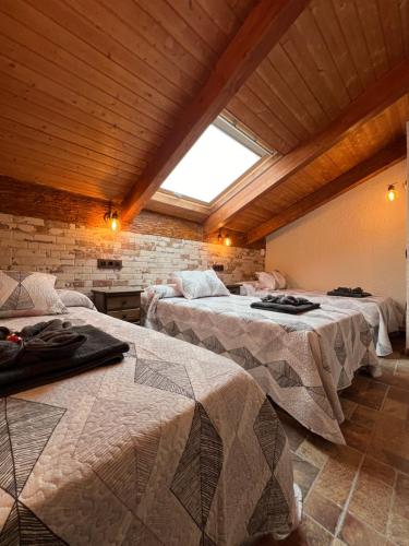 a room with two beds and a window at CASA RURAL EL TORREON in Fontiveros