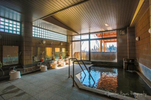 - une grande salle de bains avec une piscine d'eau dans l'établissement Morino Lodge - Myoko, à Myōkō