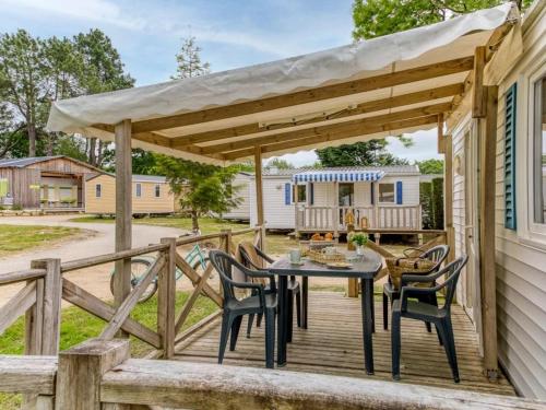 a wooden deck with a table and chairs at ZEcamping 4 étoiles pet friendly avec piscine chauffée et pataugeoire in Nesles-la-Vallée
