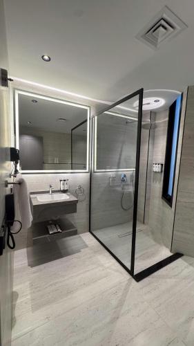 a bathroom with a shower and a sink and a mirror at Triple A Hotel in Riyadh