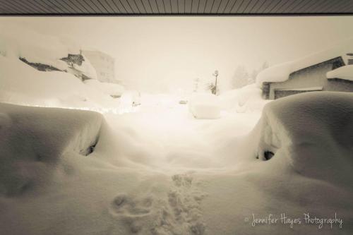 a street covered in snow in a city at Morino Lodge - Myoko in Myoko