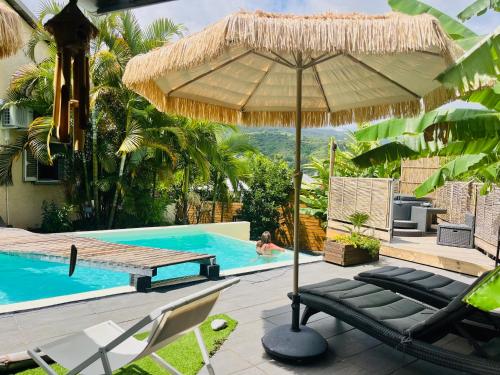 a pool with an umbrella and chairs and a swimming pool at Villa Ti MoOn, Piscine et Jaccuzi, idéalement situé, Sud Réunion in Entre-Deux