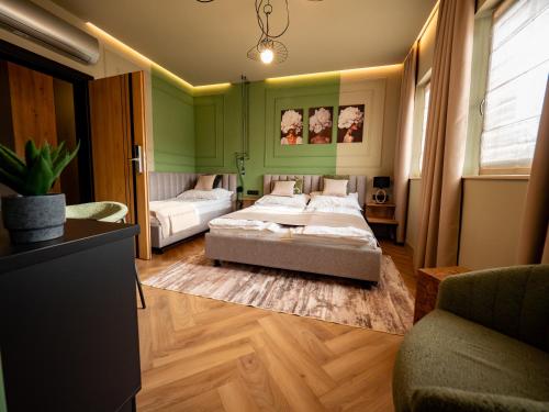 a bedroom with two beds and a couch at Premier Rooms in Szarvas