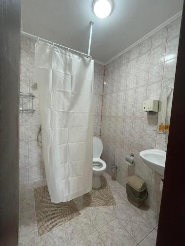 a bathroom with a white toilet and a sink at Бордуляка 11 in Ternopil