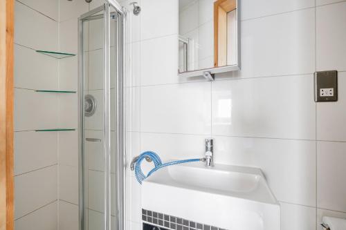 a white bathroom with a sink and a shower at Berkeley Street Residences in London