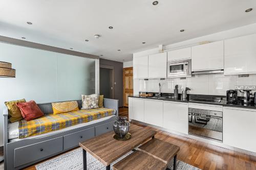 a living room with a couch and a kitchen at Berkeley Street Residences in London