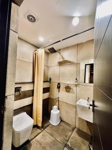 a bathroom with a toilet and a sink at IGNIVA Airport Hotel in Calicut