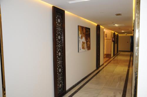 a hallway in a hotel with paintings on the walls at حديقة الروز in Al Masfalah