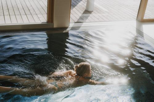 a woman is swimming in a swimming pool at Sun Lodge Schladming by Schladming-Appartements in Schladming