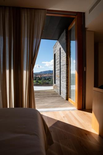 a bedroom with a bed and a window with a view at Foz Côa Story House in Vila Nova de Foz Coa
