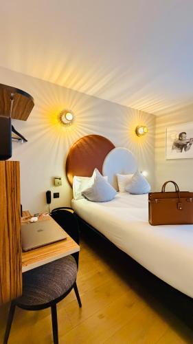 pokój hotelowy z łóżkiem i biurkiem z laptopem w obiekcie Hôtel de L'Esperance w Paryżu