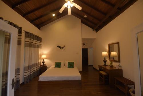 a bedroom with a bed and a ceiling fan at Chaminrich Villa and Homestay in Kandy