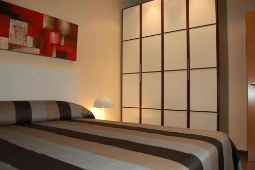 a bedroom with two beds and a painting on the wall at Apartamentos Rosi in Benicarló