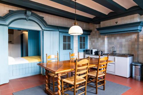 a dining room with a wooden table and chairs at Het Sluiswachtershuisje in Maassluis