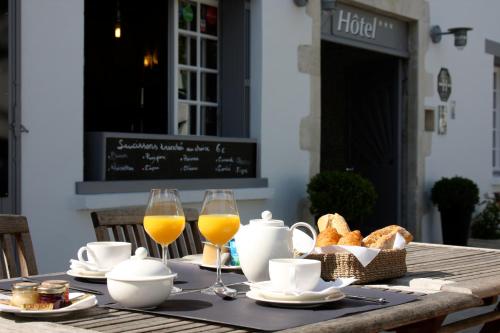 een tafel met twee glazen sinaasappelsap en brood bij Hôtel Le Vieux Gréement in La Couarde-sur-Mer