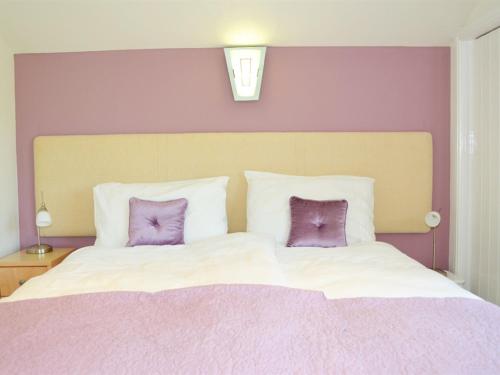a bedroom with a large bed with two purple pillows at Quixhill - Denstone - Dove Meadow B & B in Uttoxeter