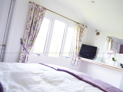 a bedroom with a bed and a window at Quixhill - Denstone - Dove Meadow B & B in Uttoxeter