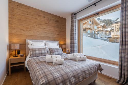 a bedroom with a bed with a large window at Guernerés & Spa by Alpine Resorts in Grimentz
