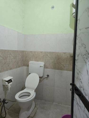 a bathroom with a white toilet in a room at Firangi Chacha in Bāra Banki