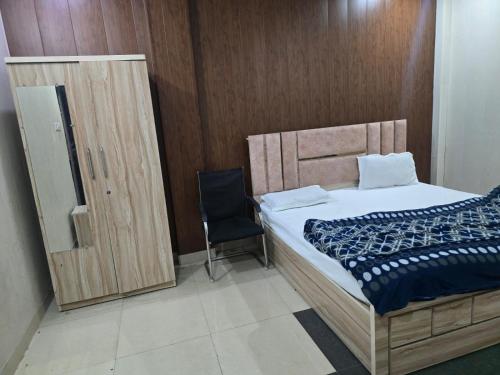a bedroom with a bed and a black chair at Firangi Chacha in Bāra Banki