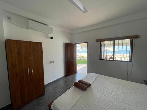 a bedroom with a large bed and a window at Saman Beach Guest House in Galle