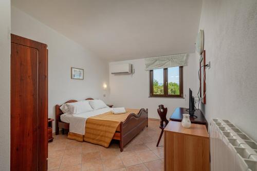 ein Schlafzimmer mit einem Bett und einem Fernseher in der Unterkunft Hotel Ispinigoli in Dorgali
