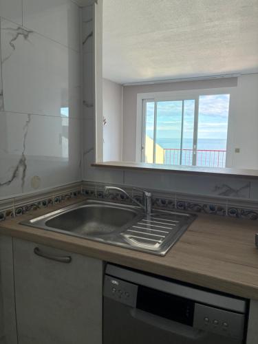 a kitchen with a sink and a window at sol appart hotel in Banyuls-sur-Mer