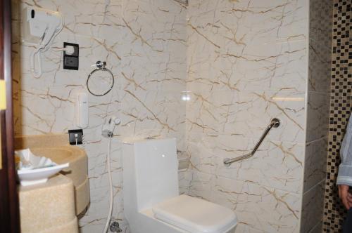 a bathroom with a toilet and a shower at حديقة الروز in Al Masfalah