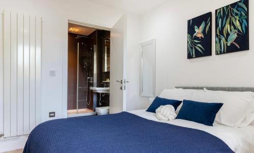 a bedroom with a blue and white bed with blue pillows at Long Stay Close To Canary Wharf - Business Travelers, Contractors, Small Families in London