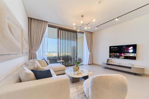a living room with a couch and a tv at Seaside Hills Al Zorah By fam Living in Ajman