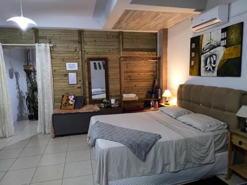 a bedroom with a large bed and a couch at Estúdio conceito aberto - 3 pessoas in Araranguá