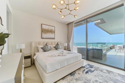 a bedroom with a bed and a large window at Seaside Hills Al Zorah By fam Living in Ajman