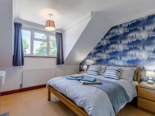 a bedroom with a large bed with blue wallpaper at 4 Bed in Southampton oc-82920 in Netley