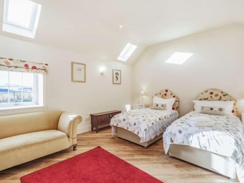a bedroom with two beds and a couch and a window at 2 Bed in Mindrum oc-86637 in Carham