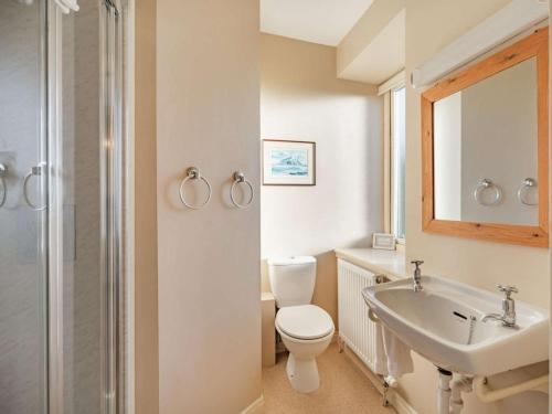a white bathroom with a toilet and a sink at 4 Bed in Mindrum oc-86272 in Carham