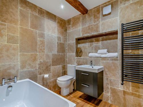 a bathroom with a tub and a toilet and a sink at 1 Bed in Leeds oc-89862 in Sherburn in Elmet